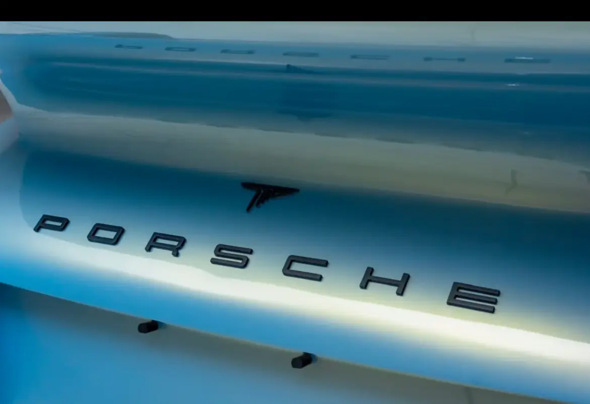 Detalhe da traseira de um Porsche com letreiro em preto fosco sobre pintura perolada
